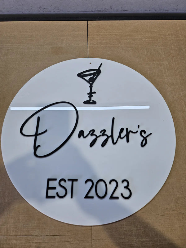 Round white Dazzler's cocktail bar sign with black lettering, est 2023