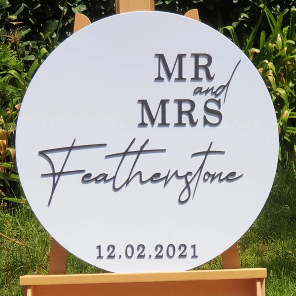 Round white Mr and Mrs Featherstone wedding sign on an easel, 12.02.2021