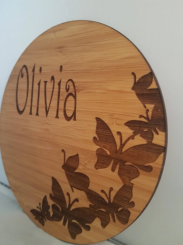Round bamboo name plaque reading Olivia with engraved butterflies