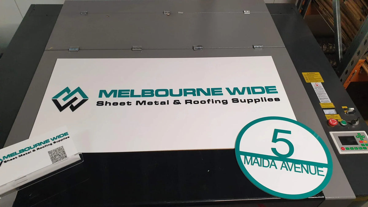 White Melbourne Wide Sheet Metal and Roofing Supplies sign on the laser cutter with a house number disc