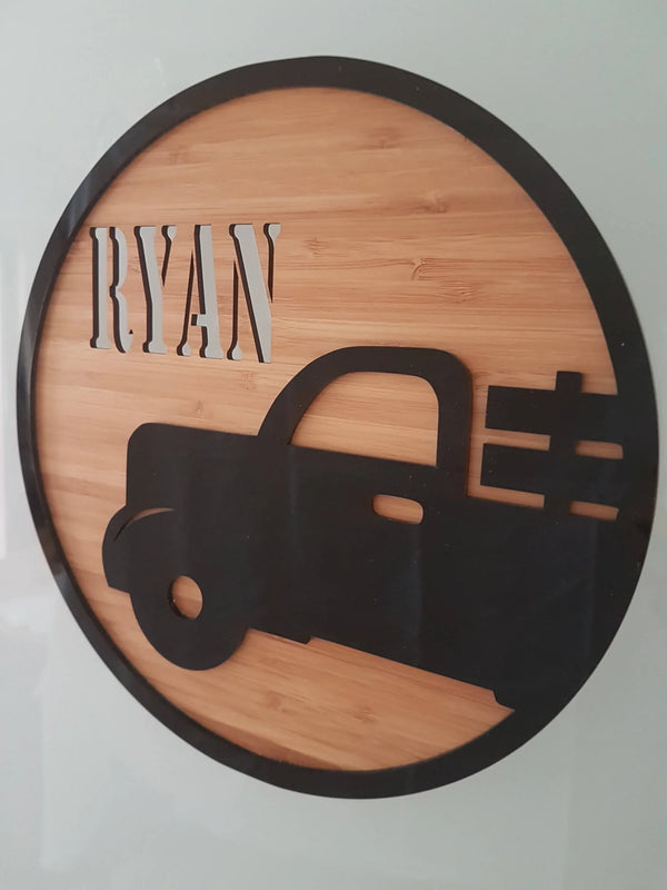 Round bamboo name plaque reading Ryan with a black acrylic vintage truck