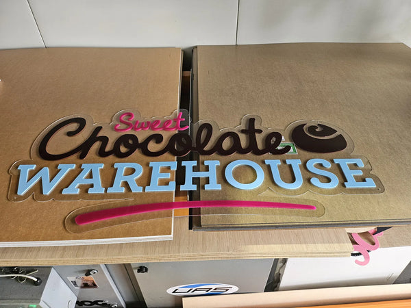 Layered Sweet Chocolate Warehouse sign in brown, blue and pink
